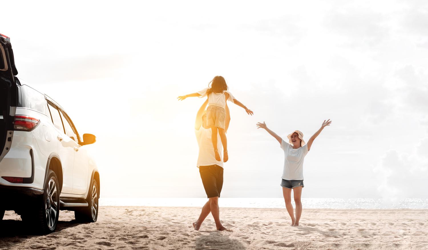 Mit weißem Auto am Strand parken, Kinder laufen im Sand