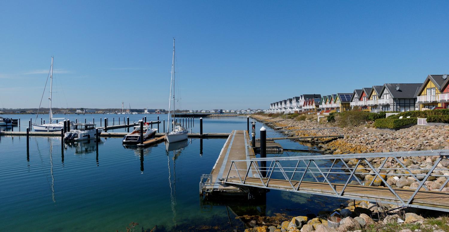 Hafen in Kappeln mit angelegten Booten und farbenfrohen Reihenhäusern an der Küste.
