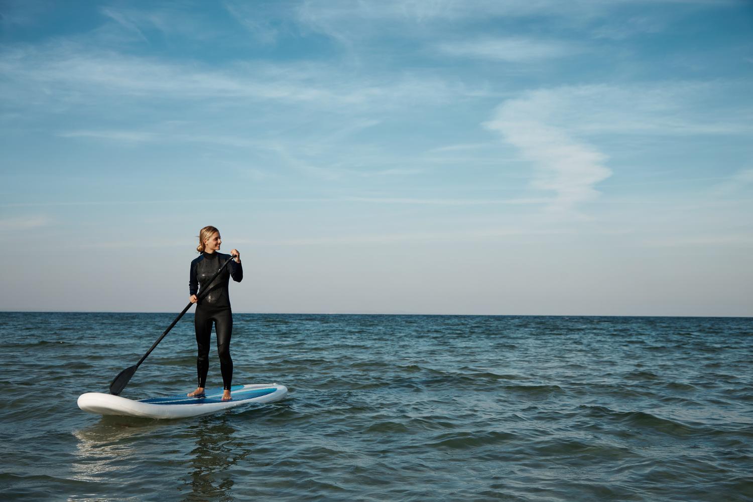 Frau beim Stand-Up-Paddling auf ruhiger See in Olpenitz